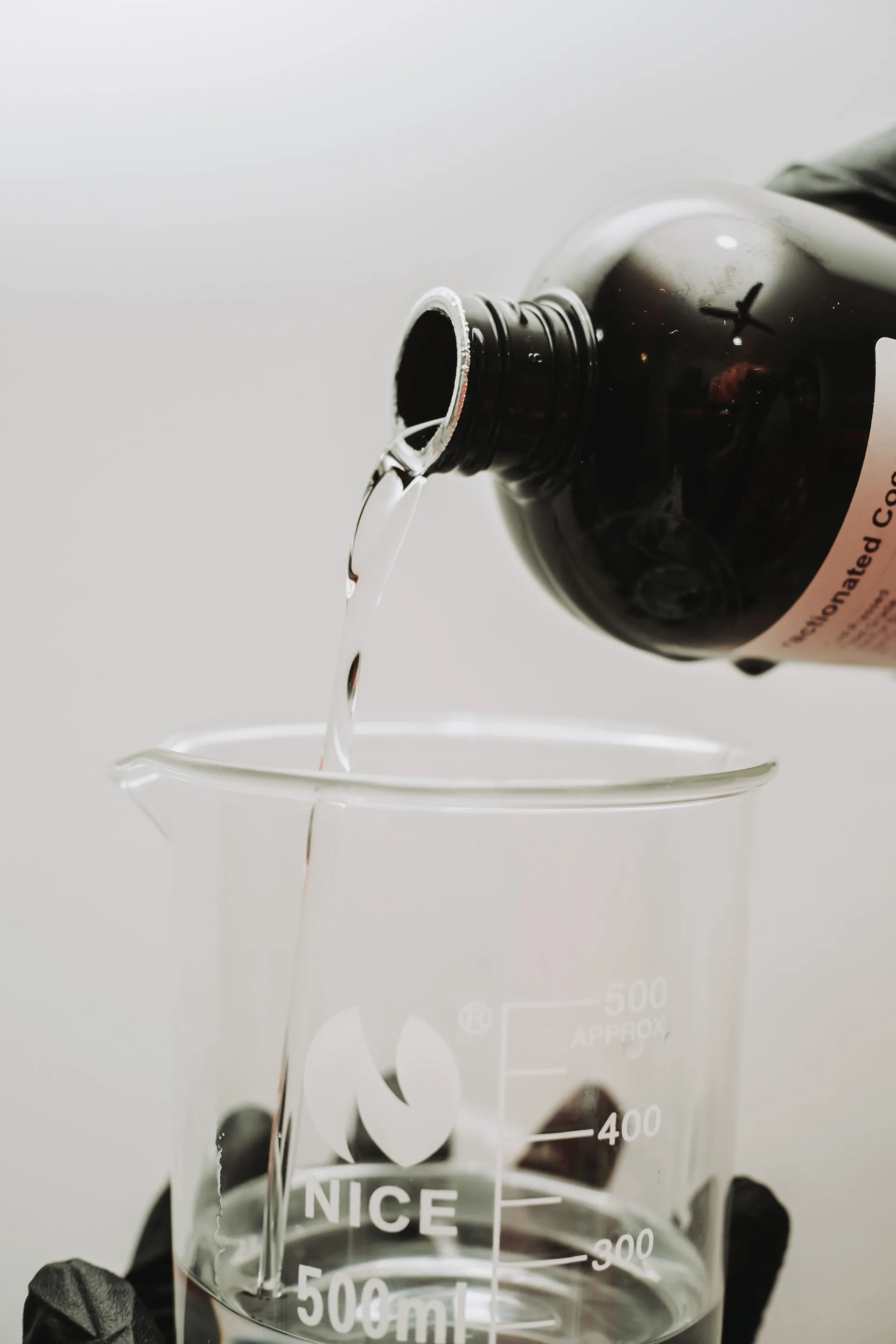 Oil being poured into a measuring beaker