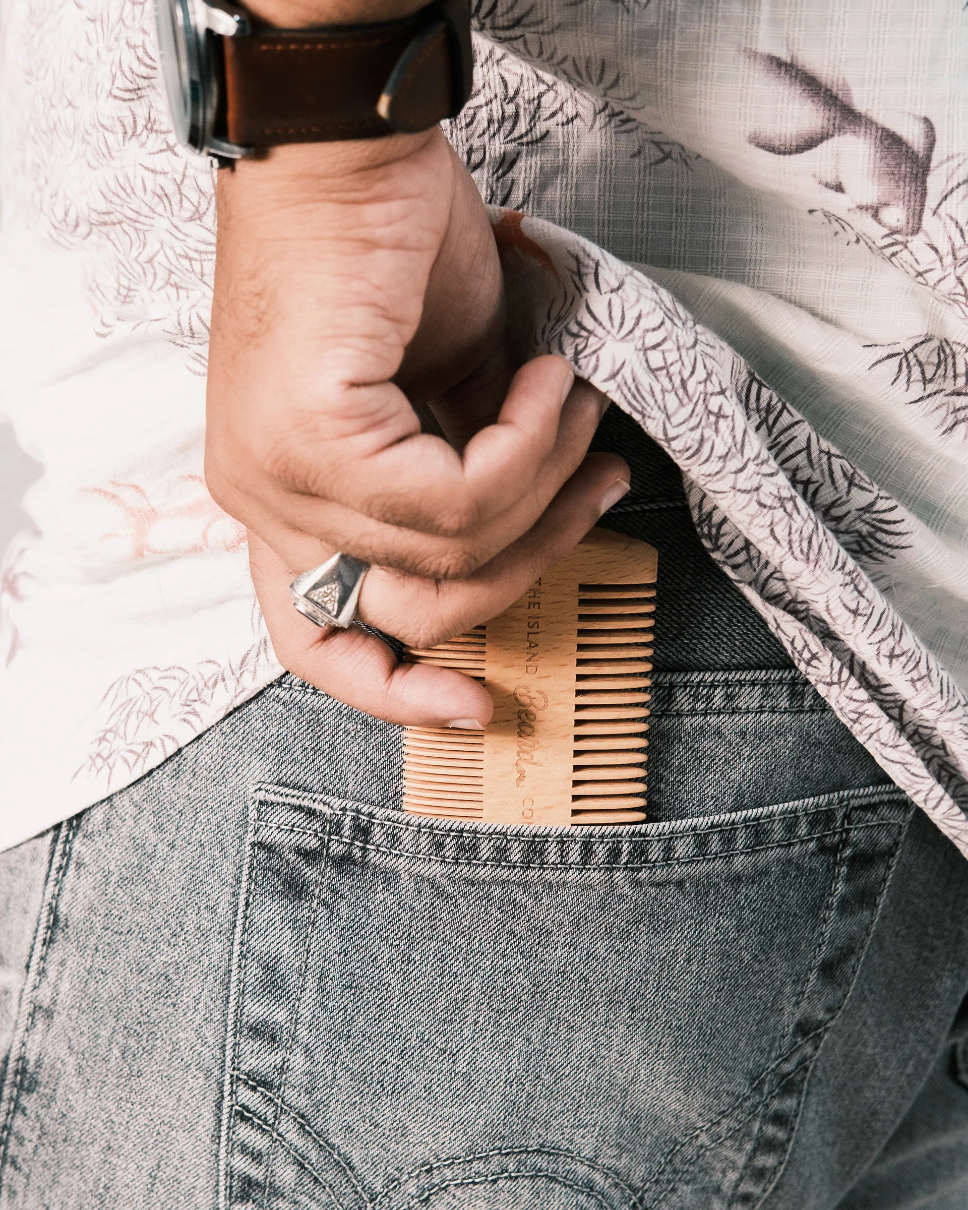 Wooden beard comb tucked into a jeans pocket