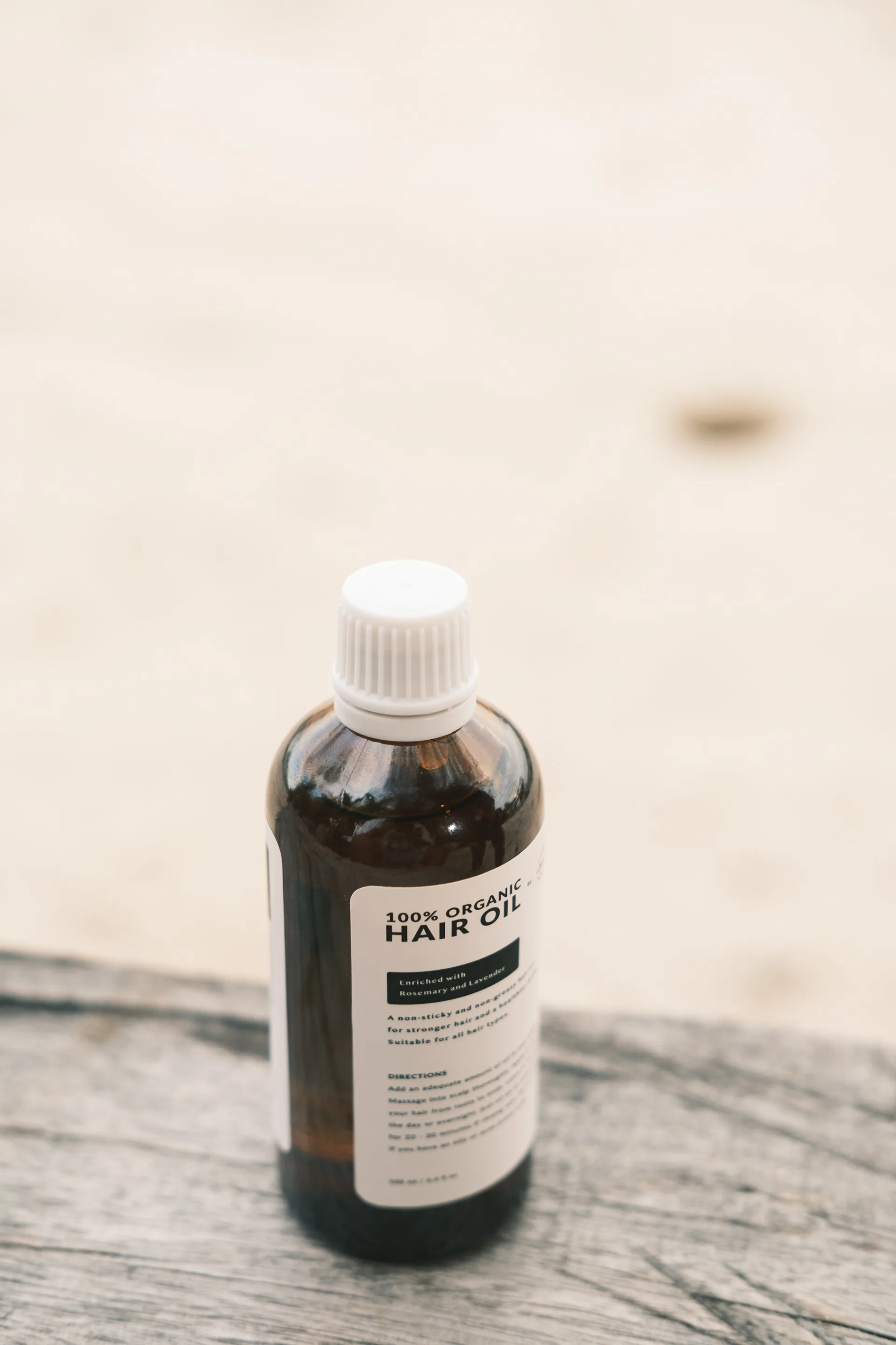 Hair oil bottle on a wooden surface
