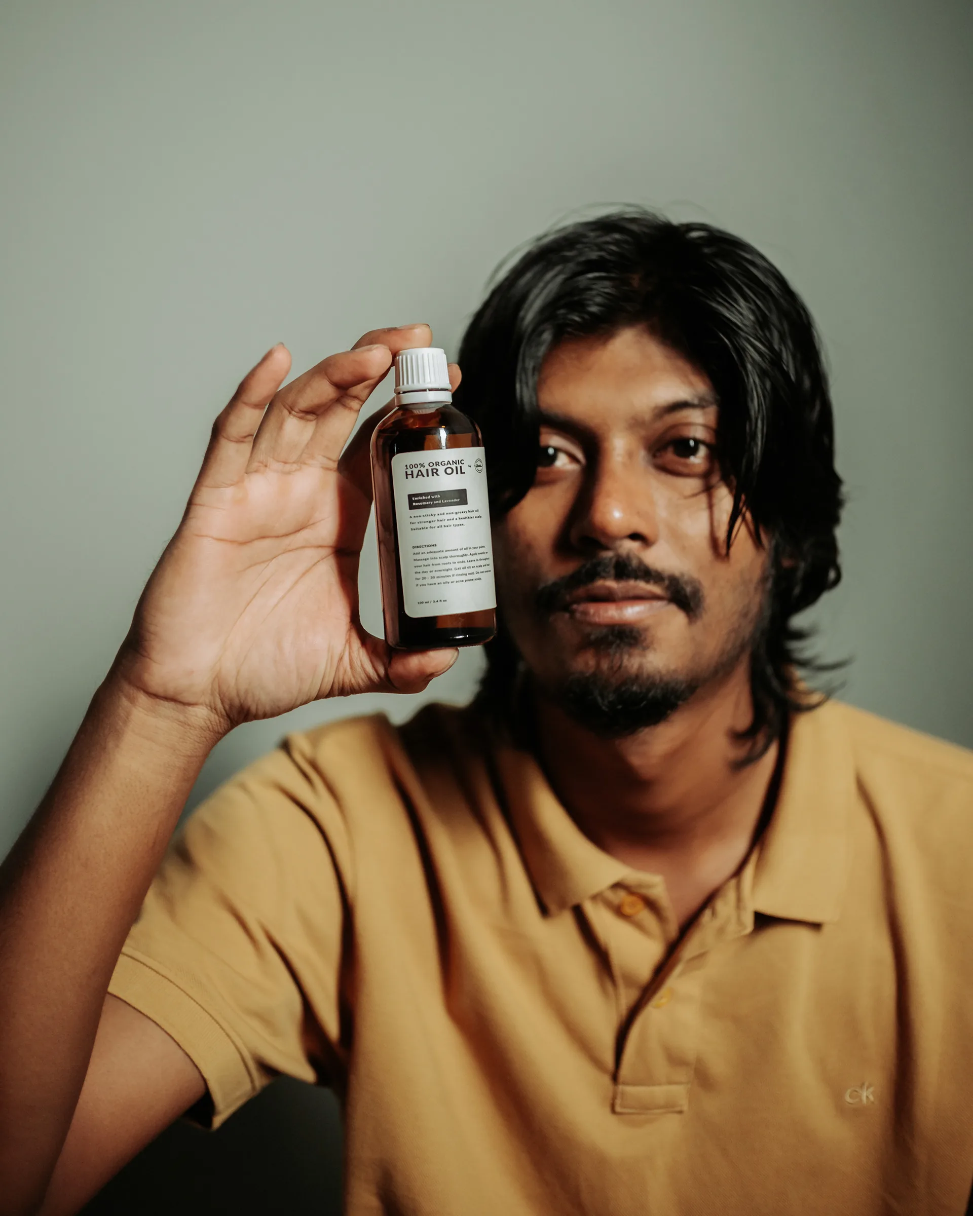 Man holding a bottle of beard oil